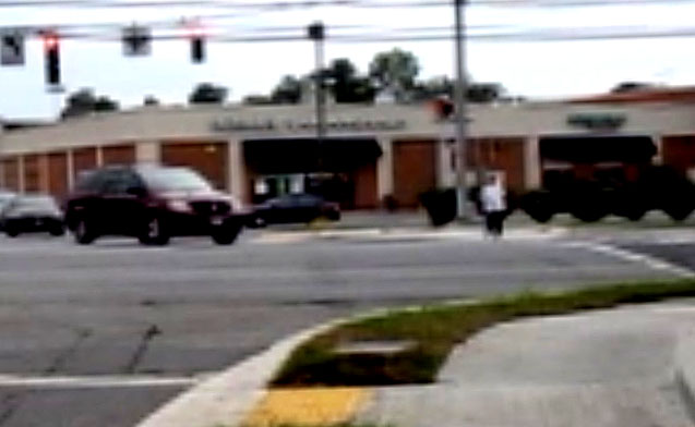 3 photos show Dona starting to cross with parallel street on her right, and vehicles are moving forward from the parallel street on her right and turning left in front of her.  The first vehicle approaches her and cuts in front of her.